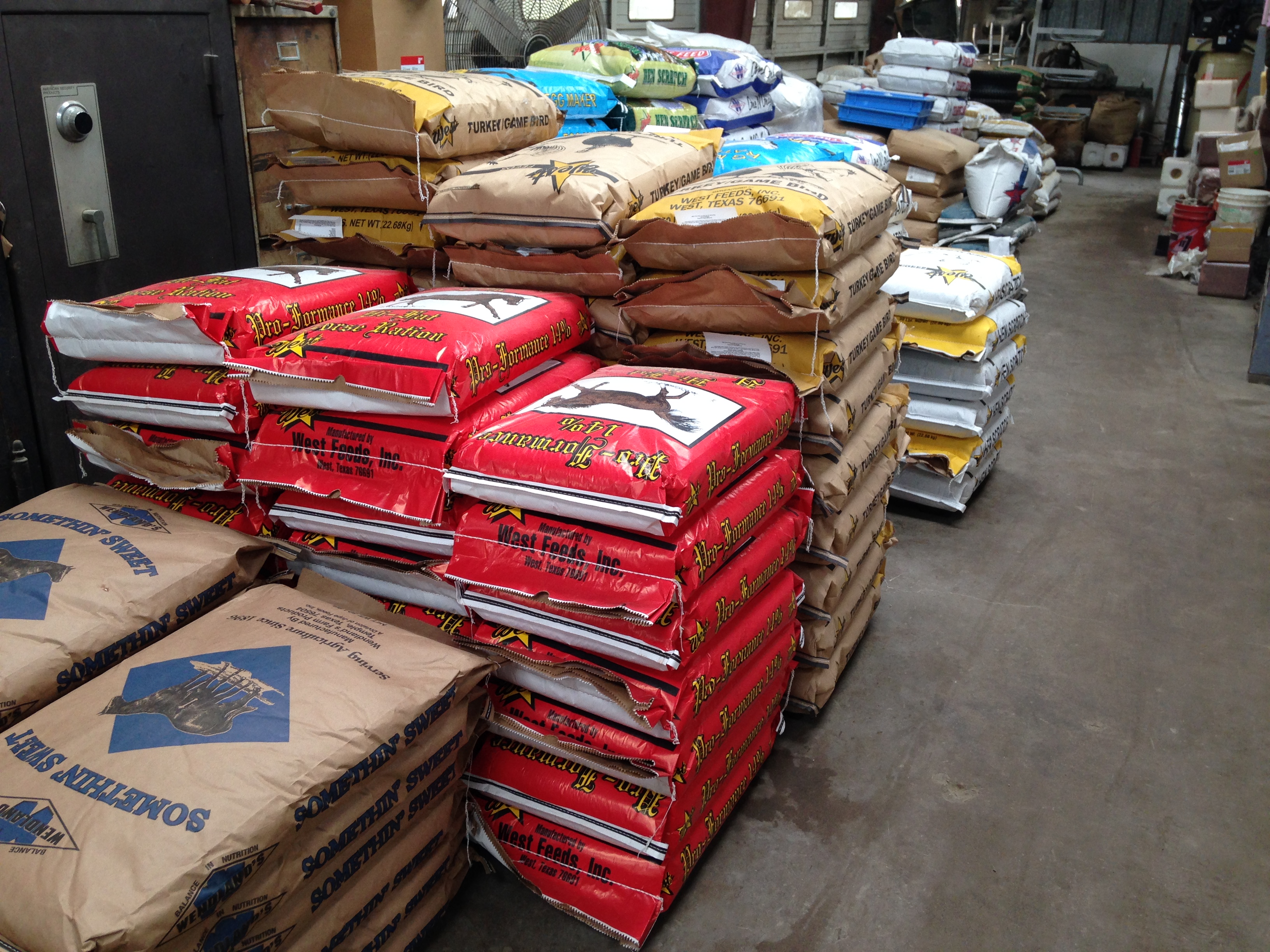 Bags of horse ration and poultry feed stacked on shelves at our Huntsville, Texas store
