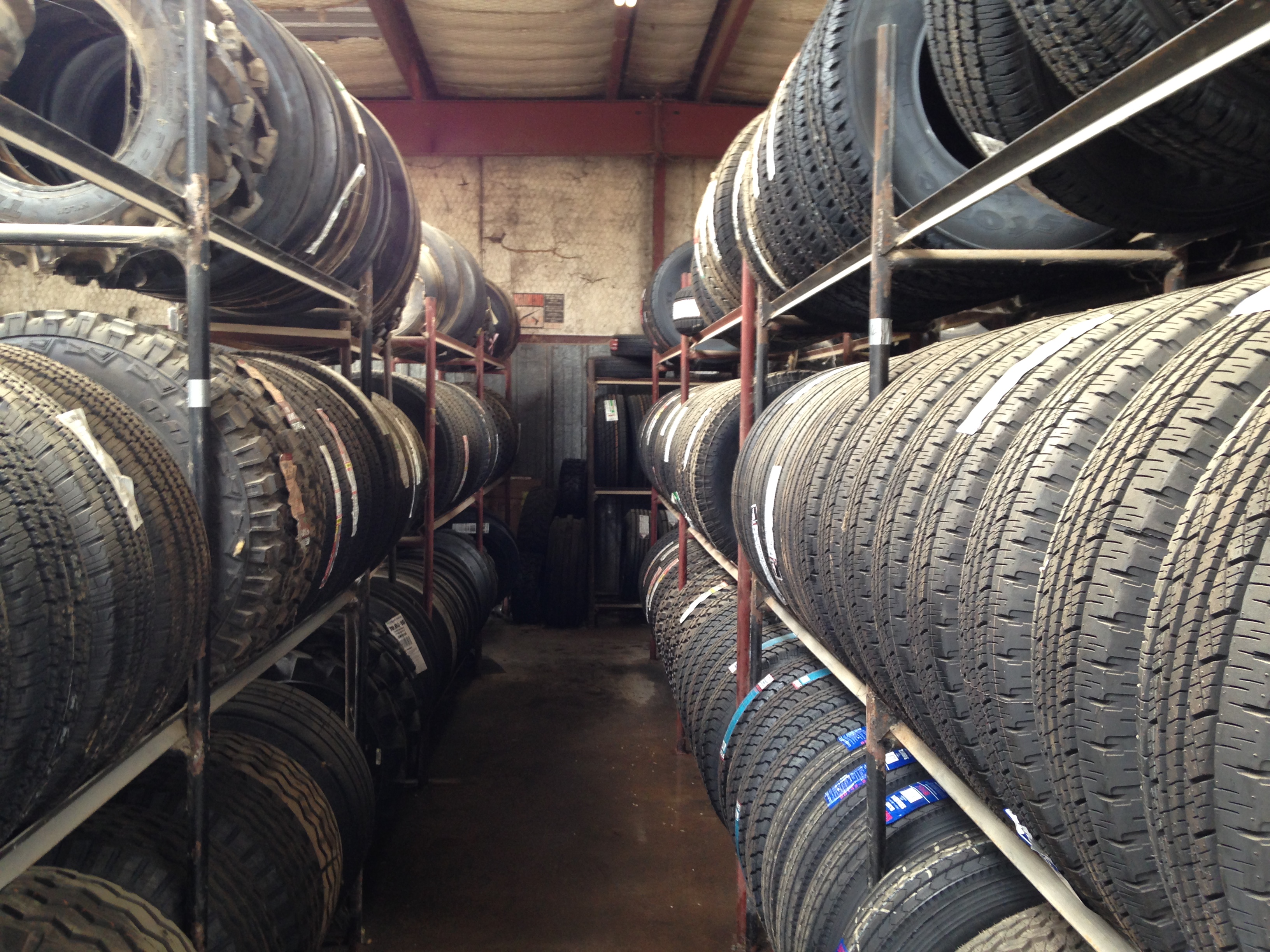 Rows of tires stocked on warehouse racks inside the A-1 Tire & Feed shop
